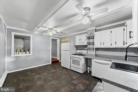 a kitchen with white cabinets and appliances