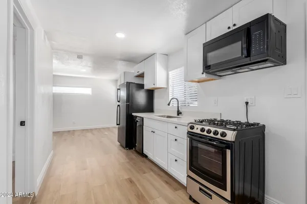 a kitchen with stainless steel appliances a stove a microwave oven cabinets and a counter top space