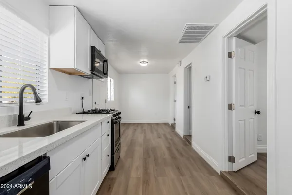 a kitchen with stainless steel appliances granite countertop a sink and a stove top oven