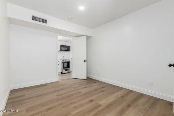 an empty room with wooden floor and a window