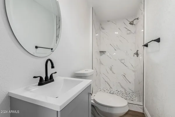 a bathroom with a sink a toilet and shower