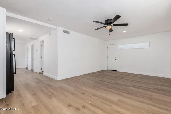 a view of a livingroom with a ceiling fan and wooden floor