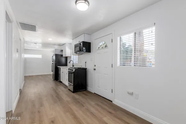 a view of a kitchen with a sink wooden floor and a window