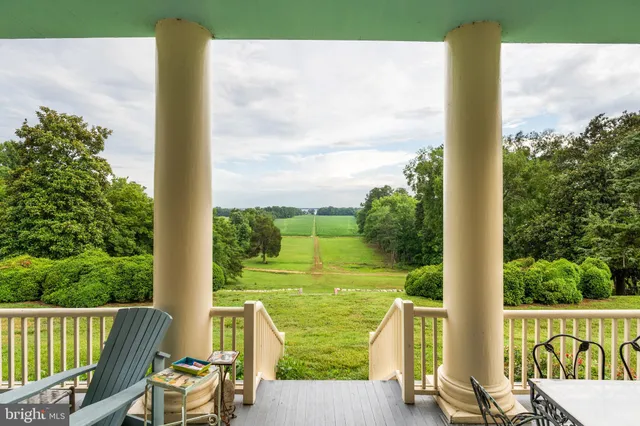 a view of backyard with green space and wooden fence