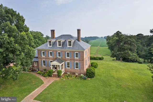 a aerial view of a house with a big yard plants and large trees