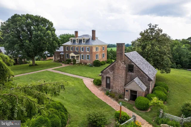 an aerial view of residential house with outdoor space and trees all around