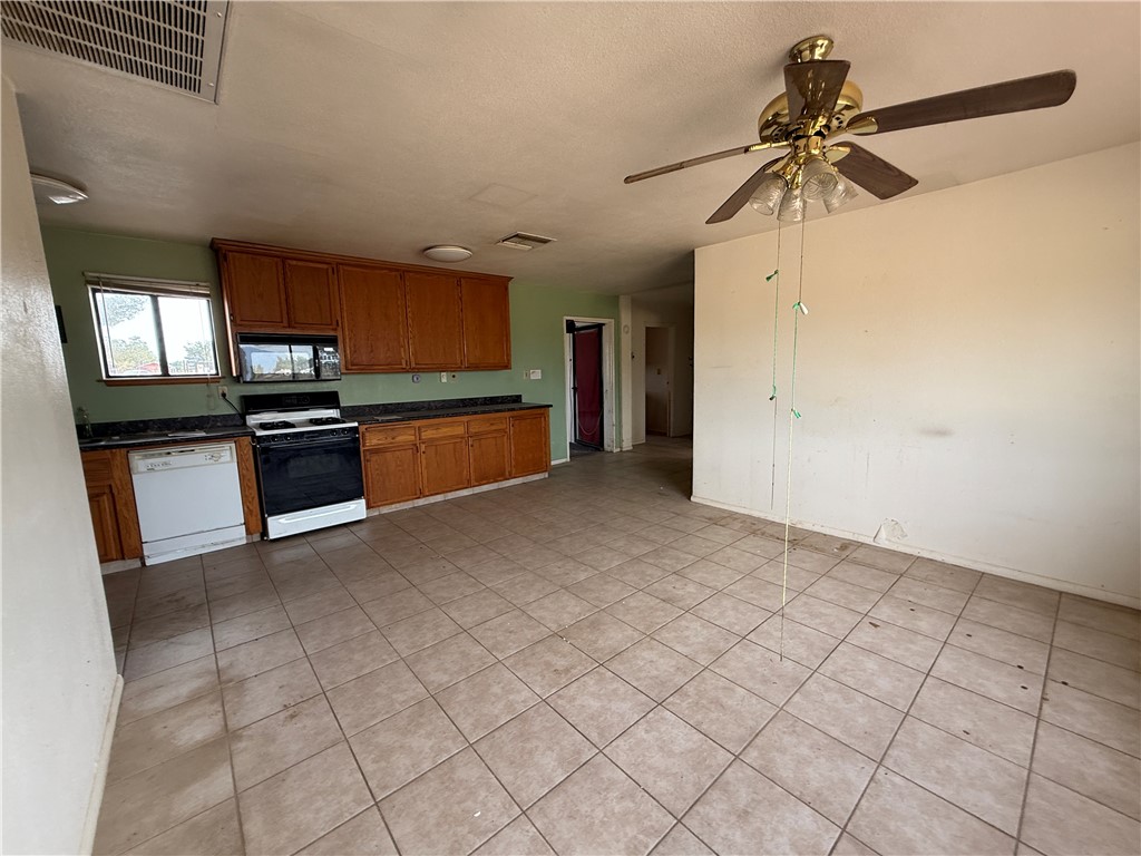 3443 3rd Street Inyokern, CA 93527 - Photo 13 of 25 a view of a kitchen with a sink and dishwasher a stove top oven with wooden floor