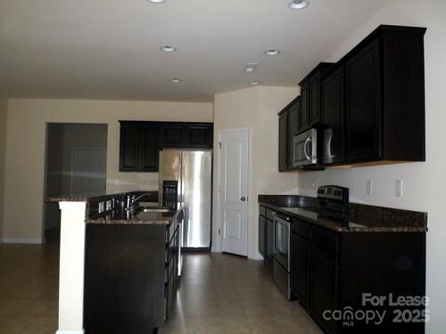 1003 Blue Stream Lane Indian Trail, NC 28079 - Photo 4 of 18 a kitchen with granite countertop stainless steel appliances a refrigerator stove and microwave