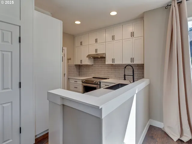 a kitchen with stainless steel appliances granite countertop a stove a sink and a refrigerator