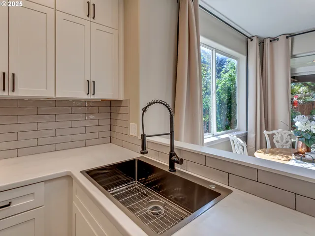 a kitchen with a sink a counter cabinets and a window