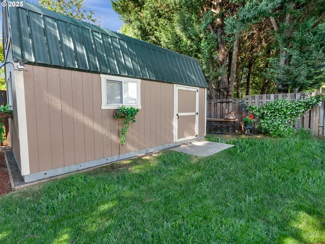 a view of a chair and table in backyard of the house
