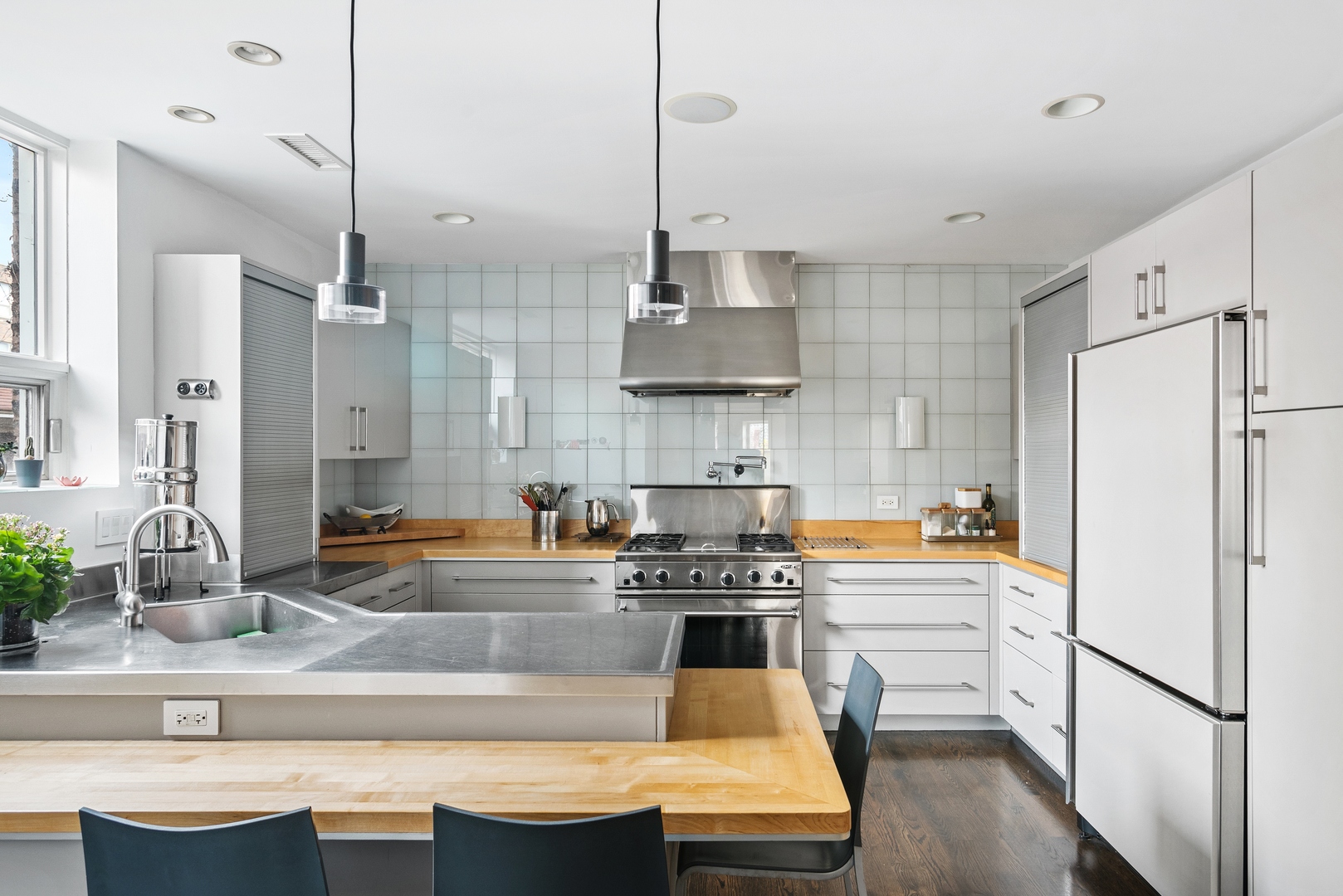 710 West Junior Terrace, Unit 2 Chicago, IL 60613 - Photo 13 of 37 a kitchen with stainless steel appliances granite countertop a sink a stove a refrigerator and island with wooden floor