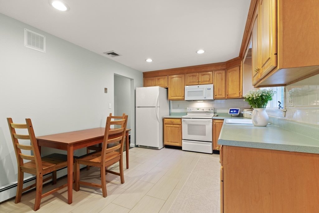33 Longmeadow Lane Sharon, MA 02067 - Photo 10 of 29 a kitchen with stainless steel appliances granite countertop a sink a stove a refrigerator with a dining table and chairs