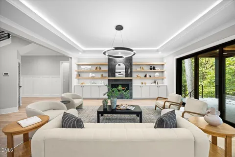 a living room with furniture a chandelier and a large window