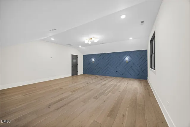 a view of a backyard with plants and large trees