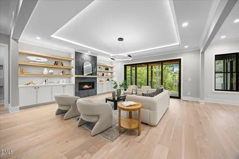 a living room with fireplace furniture and a large window