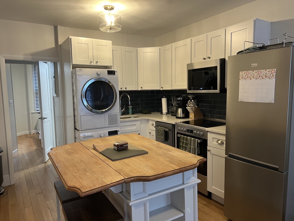 35 Grove Street, Unit 3 Boston, MA 02114 - Photo 1 of 20 a kitchen with a table chairs and a refrigerator