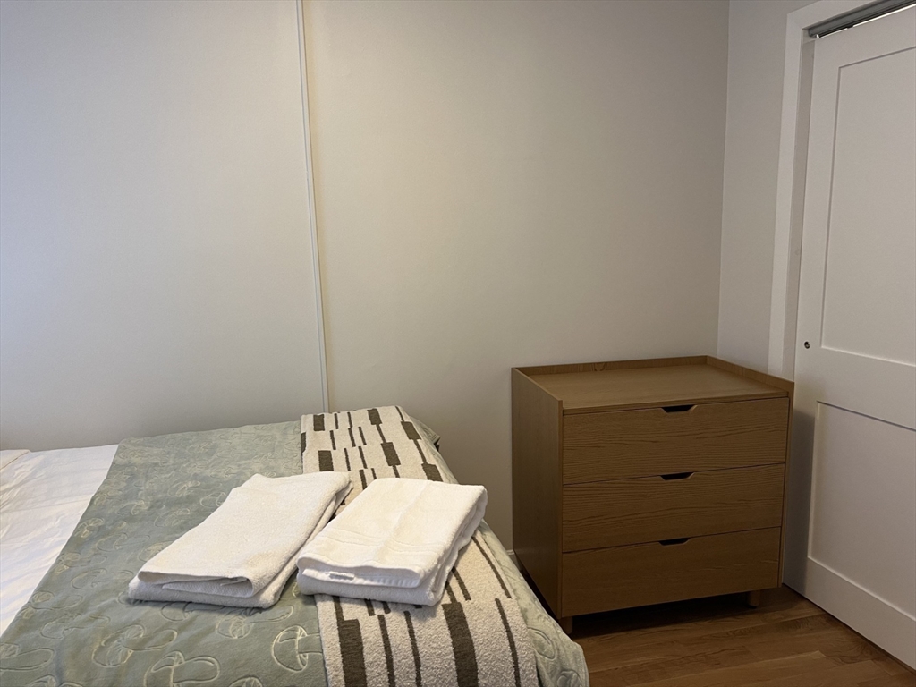 35 Grove Street, Unit 3 Boston, MA 02114 - Photo 10 of 20 a view of a room that has a bed and a dresser in it