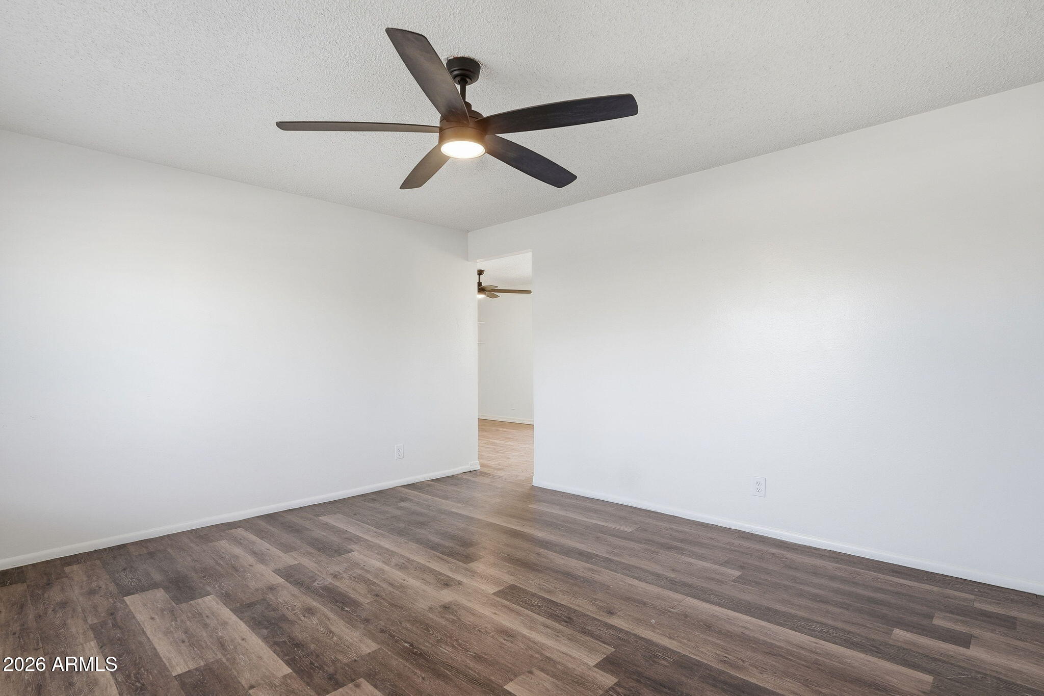 2302 East Nisbet Road Phoenix, AZ 85022 - Photo 10 of 22 an empty room with wooden floor and ceiling fan