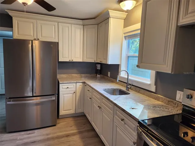 a kitchen with a refrigerator a sink and cabinets