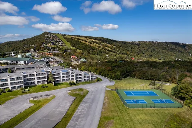 a view of a big building with a big yard and large trees