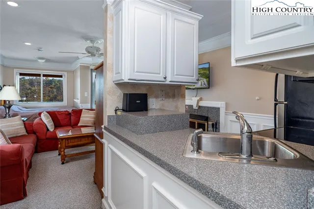 a kitchen with granite countertop a sink and a refrigerator