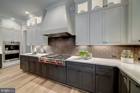 a kitchen with stainless steel appliances granite countertop a sink stove and cabinets