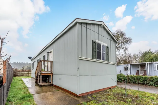 a view of backyard of house and car parked