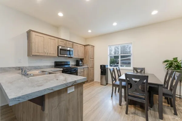 a kitchen with a table chairs microwave and cabinets