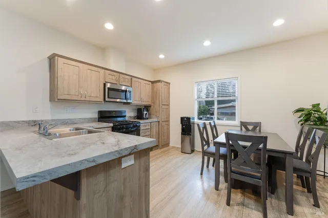 a kitchen with a table chairs microwave and cabinets