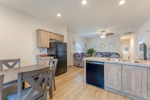 a kitchen with kitchen island a stove a sink dishwasher and a refrigerator with wooden floor