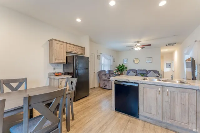 a kitchen with kitchen island a stove a sink dishwasher and a refrigerator with wooden floor