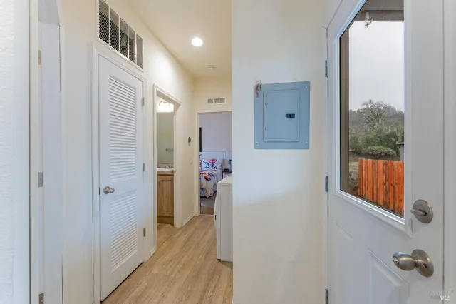 a view of a hallway with wooden floor and windows