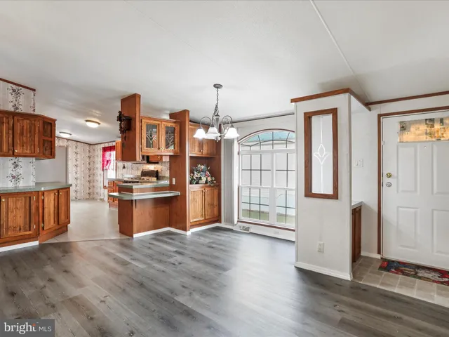 a room with kitchen island granite countertop wooden floors and wide window