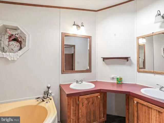 a spacious bathroom with a tub sink and mirror