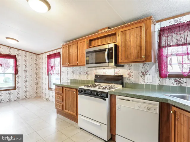 a kitchen with stainless steel appliances granite countertop a stove top oven a sink dishwasher and microwave oven