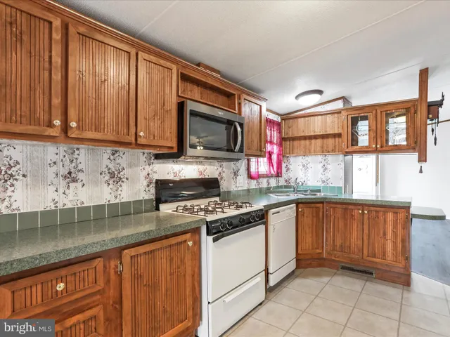 a kitchen with stainless steel appliances granite countertop a stove sink and cabinets