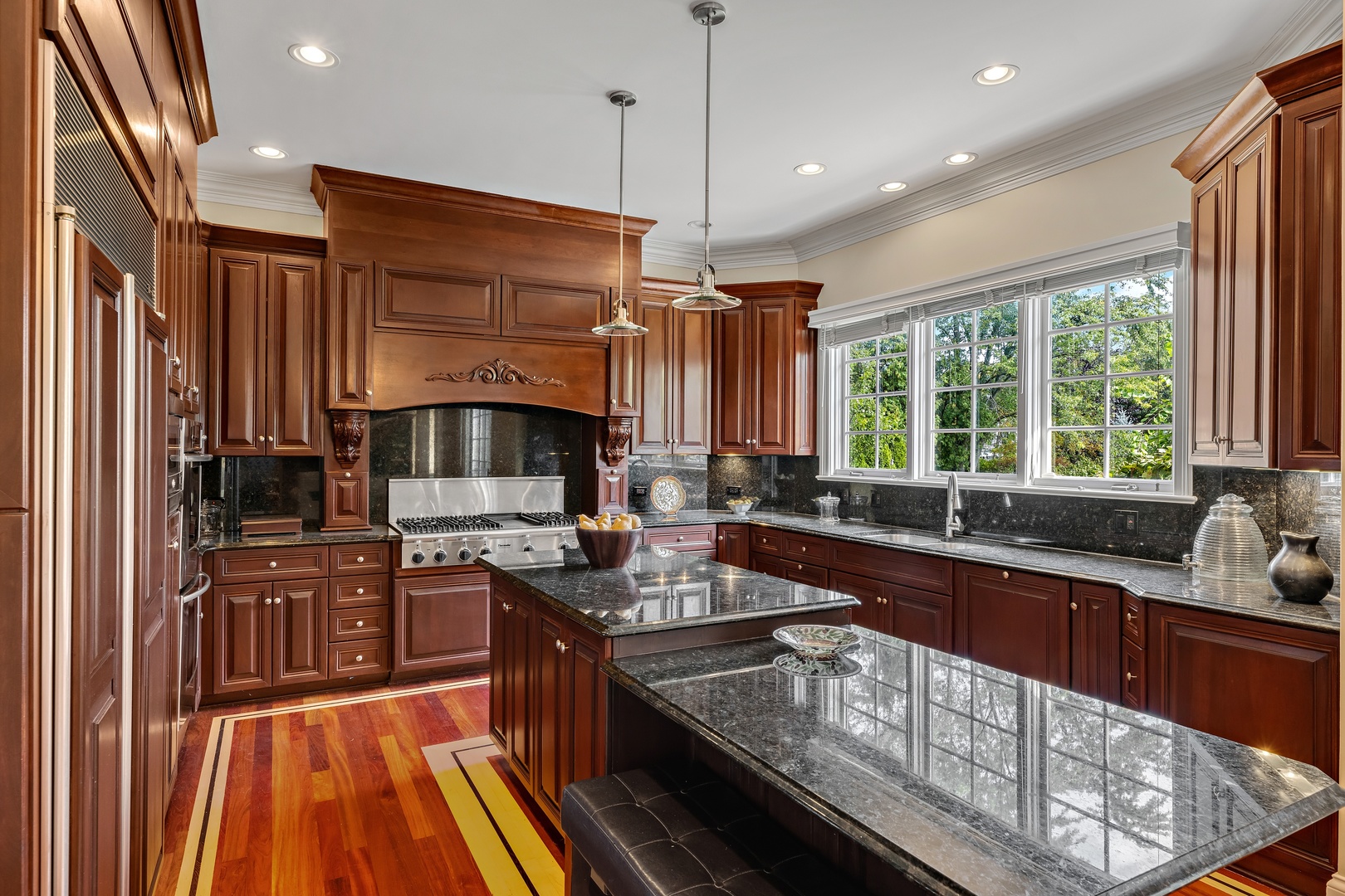 425 Sunset Ridge Road Northfield, IL 60093 - Photo 7 of 53 a kitchen with kitchen island granite countertop a sink stove and cabinets