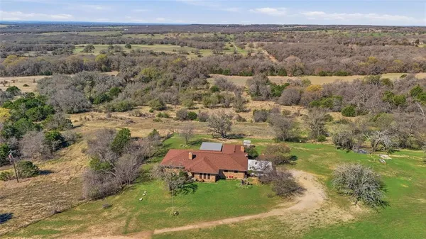 an aerial view of a house with a yard and trees