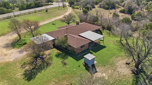 an aerial view of a house with a yard and lake view