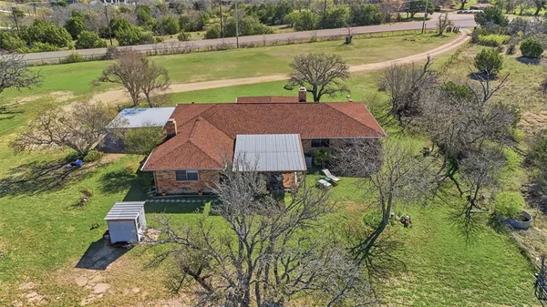 an aerial view of a house with yard and lake view