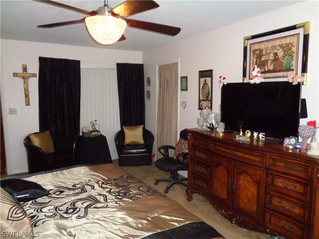 117 Delaware Road Lehigh Acres, FL 33936 - Photo 6 of 9 a bedroom with a bed and flat screen tv