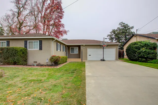 front view of a house with a yard and potted plants
