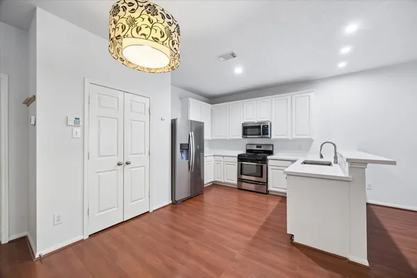 a kitchen with stainless steel appliances granite countertop a refrigerator stove and sink