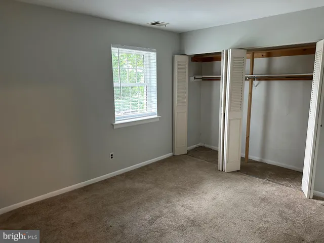 an empty room with closet and a window