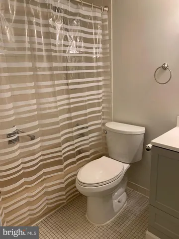 a white toilet sitting next to a shower curtain