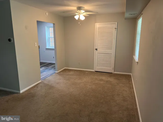 an empty room with closet and a chandelier fan