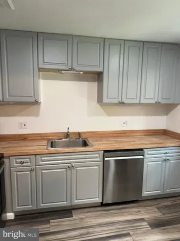 a view of a kitchen with stainless steel appliances granite countertop a sink and cabinets