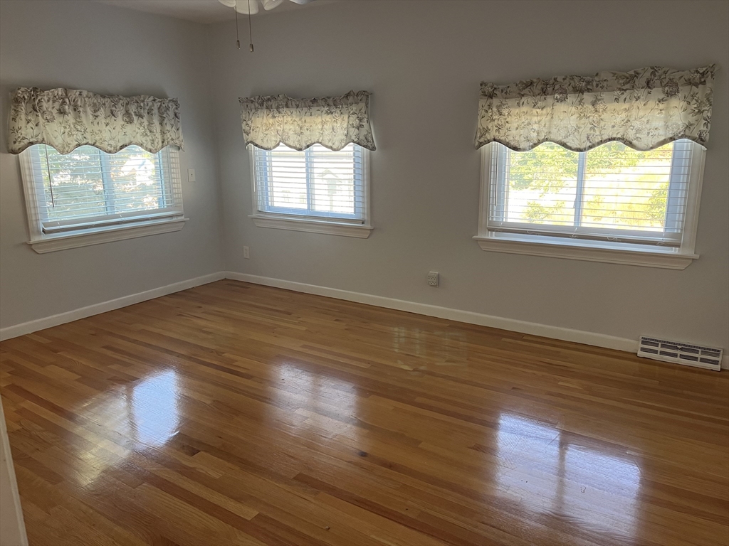21 Grove Street Saugus, MA 01906 - Photo 6 of 10 a view of an empty room with wooden floor and a window