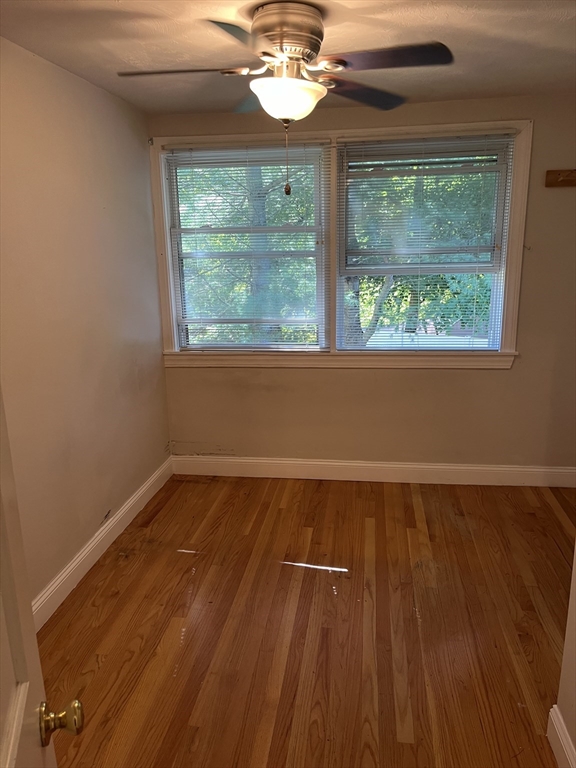 21 Grove Street Saugus, MA 01906 - Photo 8 of 10 a view of an empty room with wooden floor and a window